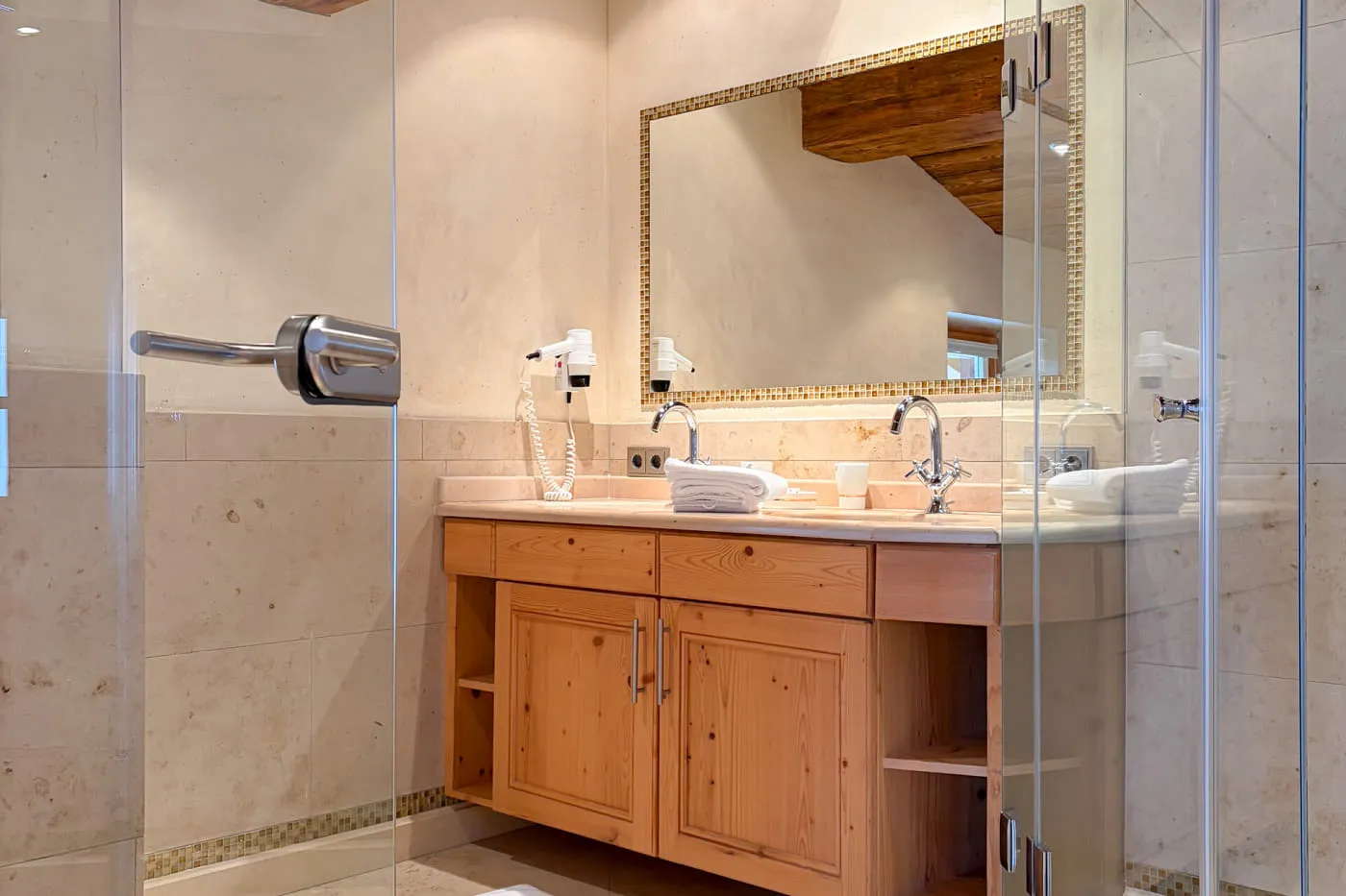 Badezimmer der Suite Rettenstein mit begehbarer Glasdusche, Waschtisch und großem Spiegel
