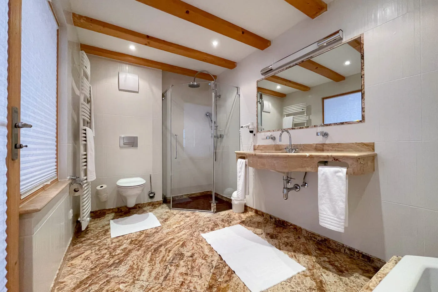 Badezimmer der Suite Mountain mit begehbarer Dusche, Waschtisch und großem Spiegel